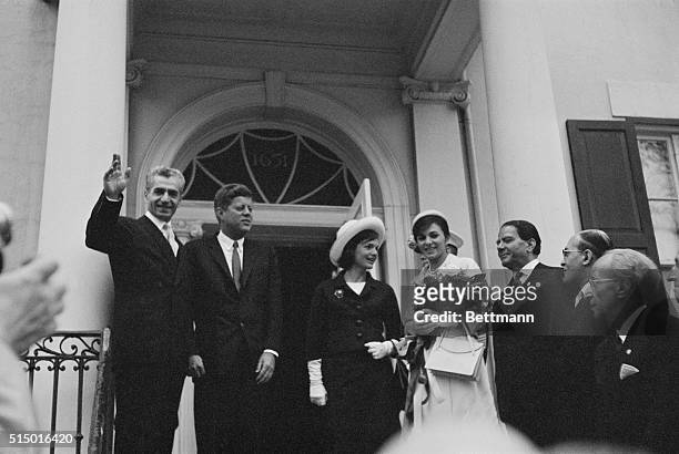 Arriving at Blair House. Washington: Shar Mohammed Reza Pahlavi of Iran waves to newsmen after he and Empress Farah, accompanied by President and...
