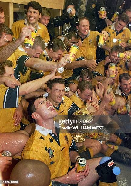 Australian center Daniel Herbert and his teammates celebrate as they pour beer in the locker room after the Rugby World Cup 1999 final game between...