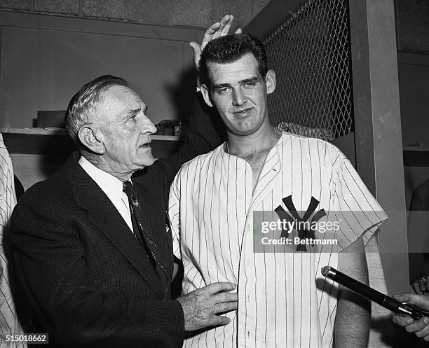 Yankee manager Casey Stengel paternally pats the head of pitcher Don Larsen who tossed a perfect no-hitter against the Dodgers to win the fifth game...