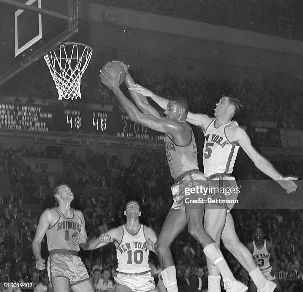 Wilt Chamberlain, center for the San Francisco Warriors, steals away a rebound from New York Knicks' center Gene Conley during a game at Madison...