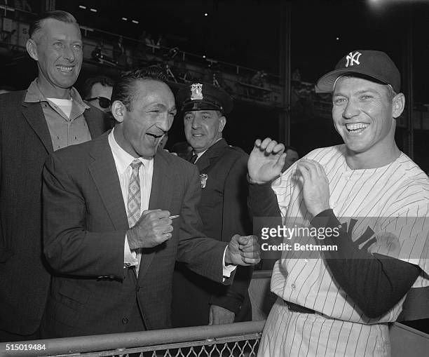 Pair of mighty sluggers engaged in a spot of pre-series clowning as Carmen Basilio, middleweight boxing champ , squares off with Mickey Mantle, who...