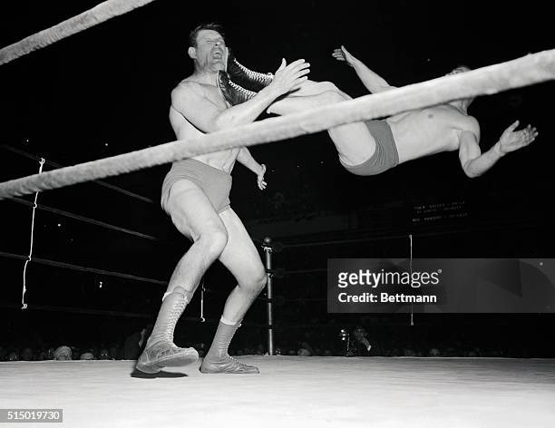 Canada's Viadek "Killer" Kowalski lets out a holler as the feet of his opponent, Australian champion Pat O'Connor land against his face during their...