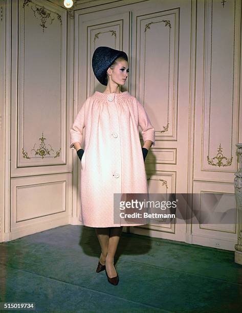 Paris: Smoking frames the collarless neckline of a barrel-shaped coat from the spring collection of Pierre Cardin. The coat is done in a creamy,...