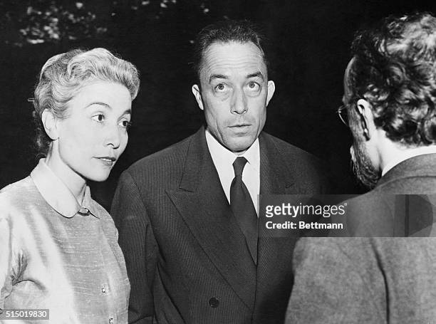 Albert Camus, French Novelist, author of The Plague- The Strange, is shown with his wife as they were interviewed by a newsman in Paris after it was...
