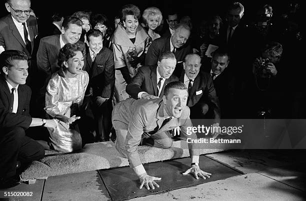 Actor Kirk Douglas , in obvious high spirits, puts his hands in the cement in front of Grauman's Chinese Theater November 1st. At right, bandleader...