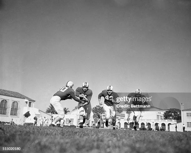 Bernie Faloney, quarterback, handing off to Chester Hanulak; Ralph Felton and Dick Nolan.