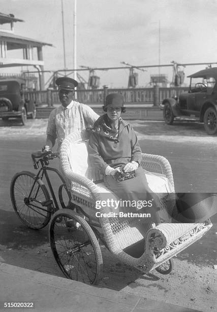 Mrs. J.D. Kuser , prominent in Palm Beach and New York social circles, rides in the back of a pedicab.