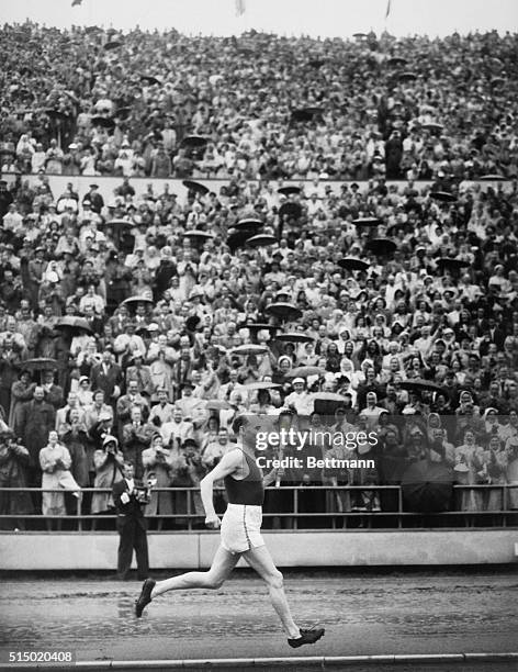 Paavo Nurmi brings Olympic Flame to Opening Ceremony. Helsinki: Paavo Nurmi sprints round the track at the Olympic Stadium here with Olympic flame,...