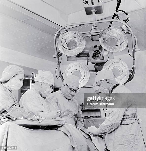 Scene in the operating room of the Walter Reed Hospital as a delicate surgical operation is demonstrated under a television color camera by Major...