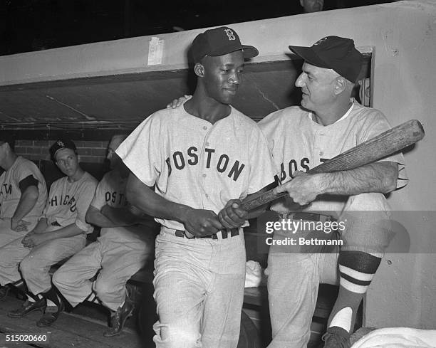 Manager Bill Jurges, of the Boston Red Sox, greets Pumpsie Green, who was recalled to the parent club from Minneapolis. Green, an infielder, became...