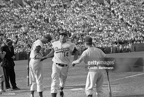 Scored Winning Run. Los Angeles, Calif.: Dodger Gil Hodges is greeted by teammate Don Demeter and Dodger batboy as he crosses the plate after hitting...