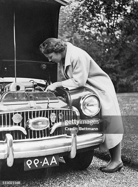 Dutch Treatment. Hague, Holland: Tinkering with the engine of her car, Princess Beatrix of Holland is a study in concentration on the palace grounds...