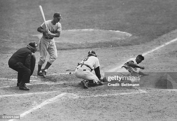 Jackie Robinson of the Dodgers slides home safely on his steal in the eighth inning of this series opener at Yankee Stadium. This was the play that...