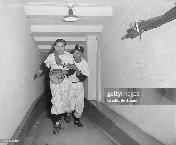 Yogi Berra is hugged by teammate Elston Howard following Berra's ninth-inning walk-off home run against the Boston Red Sox, defeating them at Yankee...