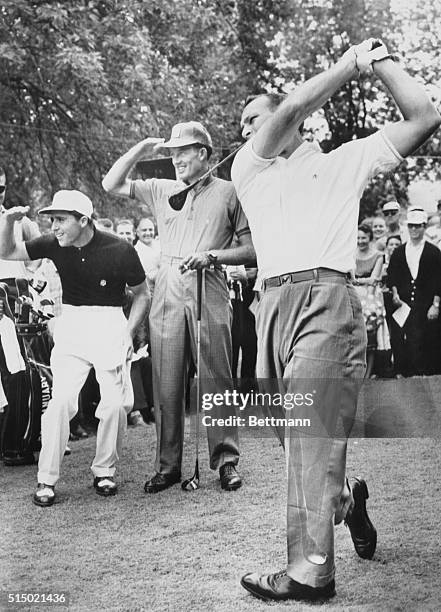 Arnold Palmer hits a tee shot on the first tee under the watchful eyes of Gary Player and Don January during the 43rd P.G.A. Tourney at Olympia...