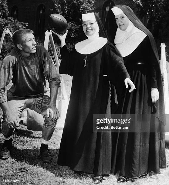 Pittsburgh Steelers' Quarterback, Johnny Unitas, shows Sister M. Theresa Hung, of Shishi, China, how they play football in the United States. Looking...