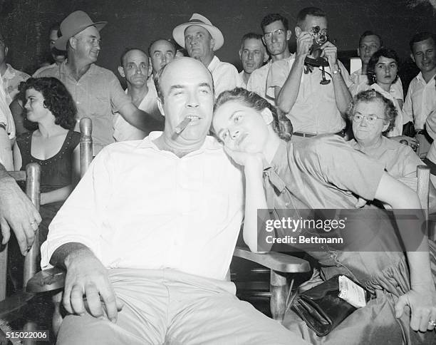 Taking Acquittal in Stride. Sumner, Mississippi: Co-defendant J.W. Milam calmly smokes a cigar as his wife mugs for the camera, after he and his...