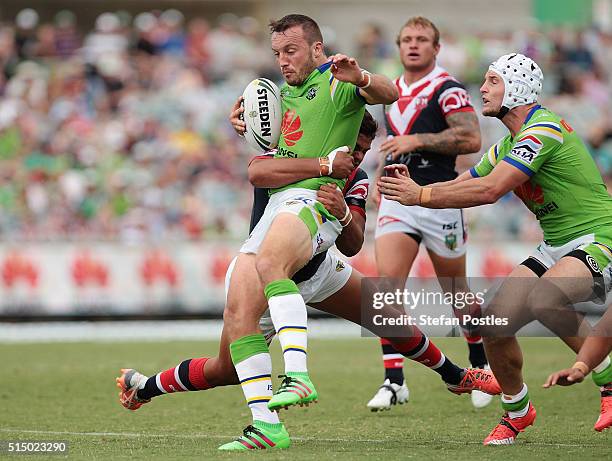 Josh Hodgson of the Raiders is tackled during the round two NRL match between the Canberra Raiders and the Sydney Roosters at GIO Stadium on March...