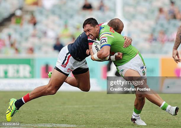 Jordan Rapana of the Raiders is tackled during the round two NRL match between the Canberra Raiders and the Sydney Roosters at GIO Stadium on March...