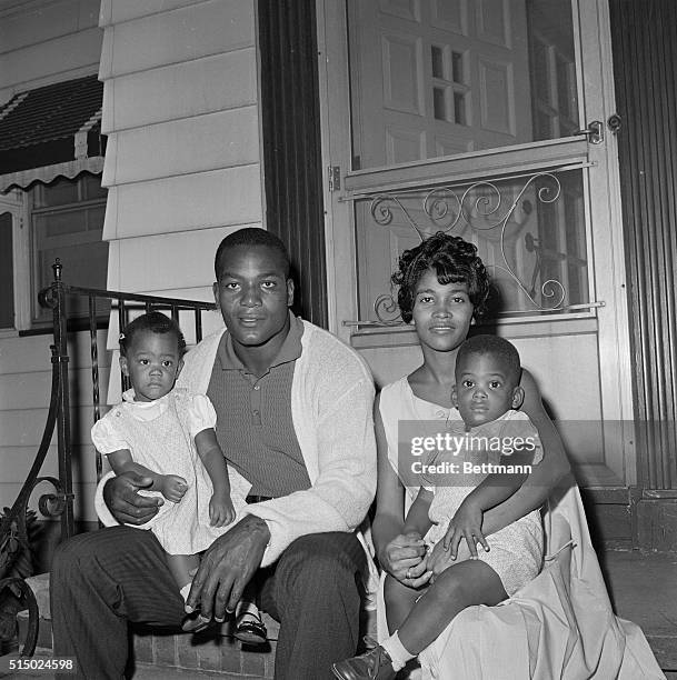 Jim Brown, fullback of Cleveland Browns, sits in front of his home with family, wife, Sue and twins Kim and Kevin, 19-months-old.