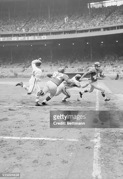 Chain Reaction: Emlen Tunnell of the New York Giants is forced out of bounds on the 20-yard line by Alex Sandusky of the Baltimore Colts while Stan...