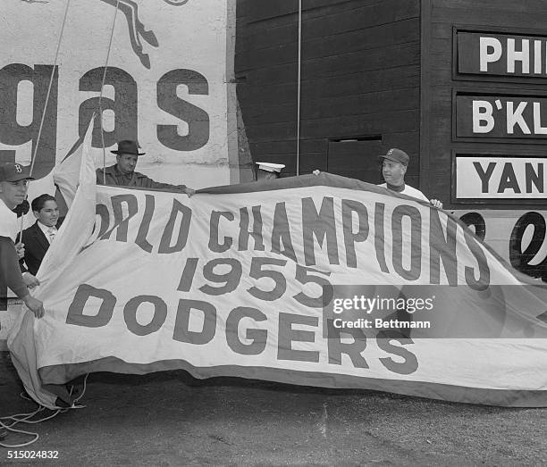 The World Series flag is proudly raised over Ebbets Field as a feature of the opening day ceremony as the Dodgers played host to the Phillies today....