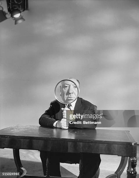 Alfred Hitchcock plays with a magnifying glass on the set of his television show Alfred Hitchcock Presents, which aired from 1955-1965.
