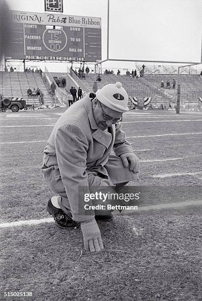 Green Bay Packers coach Vince Lombardi smiles as he checks the turf on Packer stadium 12/31. A covering of bay kept the turf from freezing, the...