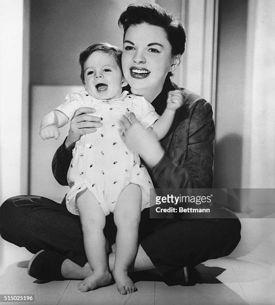 Actress Judy Garland shows off her "Little Joe: who made his television debut by photo proxy on the Judy Garland Show, on April 8th, 1956. This was...