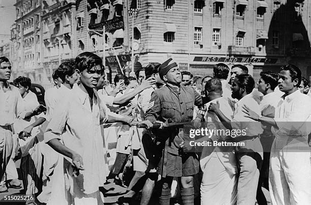 Rioters are trying to seize a policeman's rifle during the rioting in Bombay, India, last week, in protest to the government's decision to make...