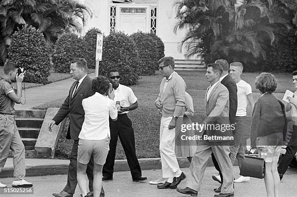 President John F. Kennedy is surrounded by tourists as he walks with Secret Service agents from his automobile to St. Mary' hospital.
