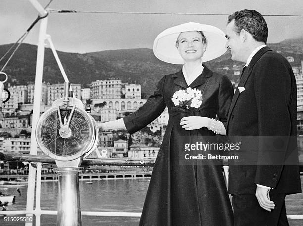 Charming and smiling Grace Kelly stands looking towards the principality of Monaco with her hand on the engine room telegraph of Price Rainer's...