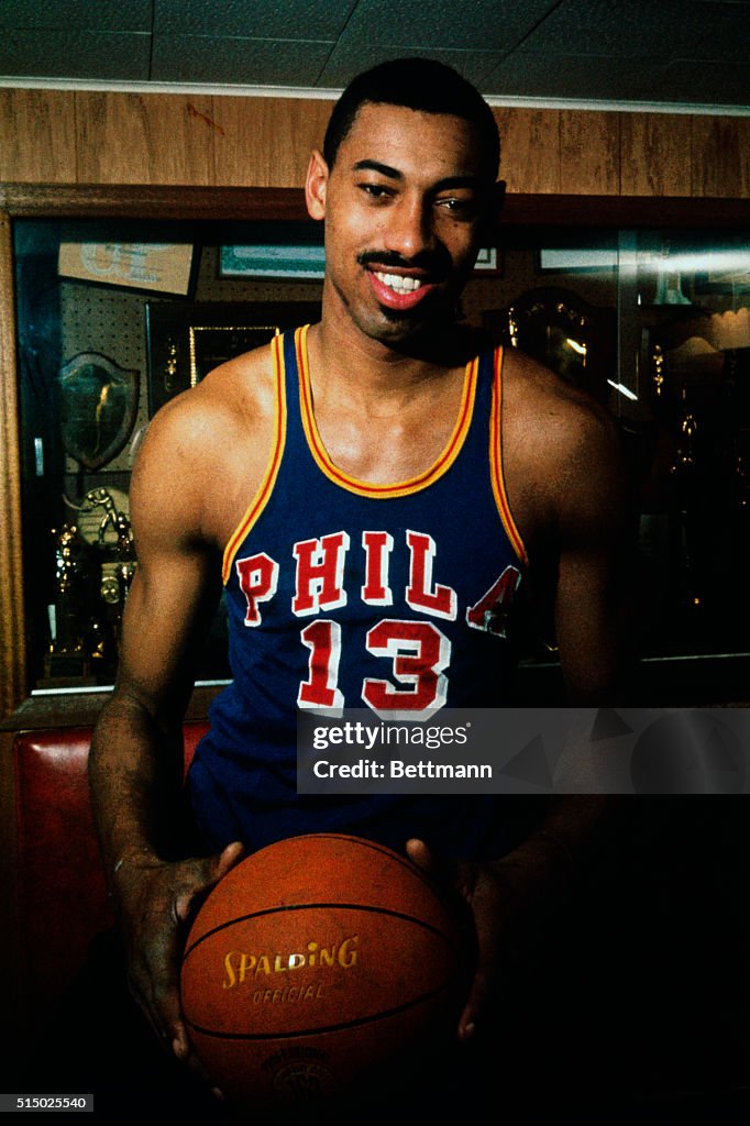 Wilt Chamberlain Standing by Trophy Display