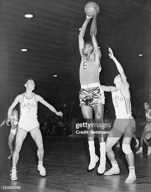 Big Bill Russell of the U.S. Team is shown out-rebounding two members of the Japanese team, H. Saito and T. Itoyama in the U.S. Japan basketball game...