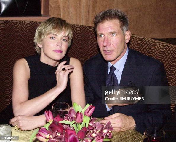 Harrison Ford and Sharon Stone share a table at the GQ Magazine party ...