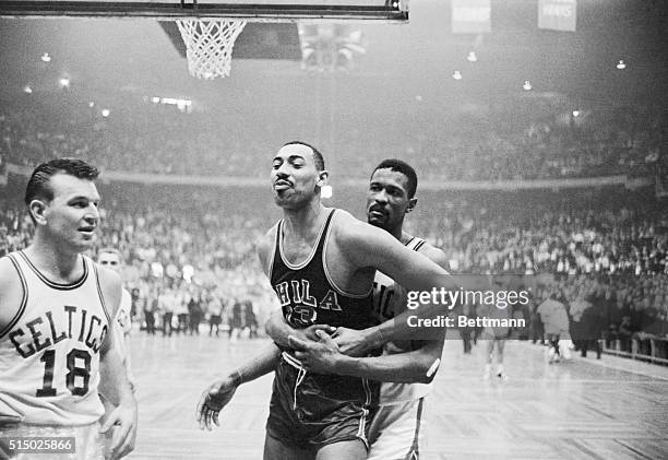 Boston: Celtics' Bill Russell pins Warriors' Wilt Chamberlain's right arm, and holds him, during wild 4th quarter in which both sides fought. Boston...