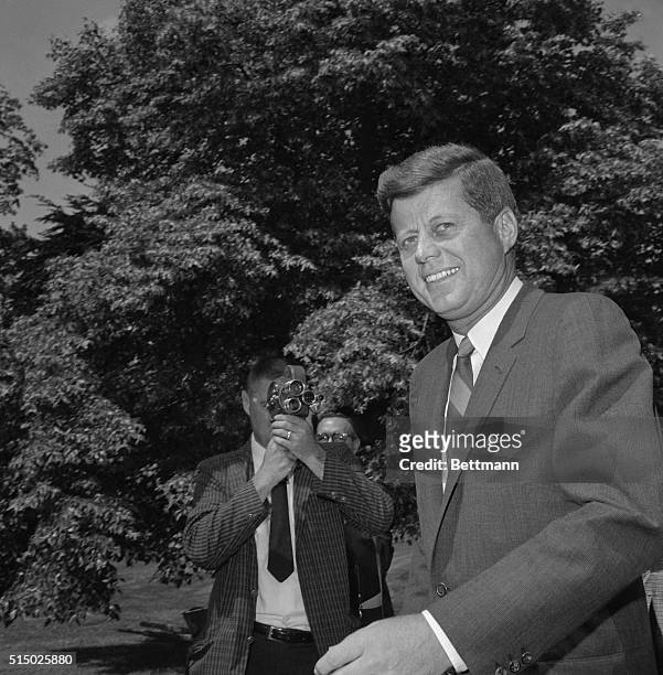 President Kennedy smiles for newsmen as he leaves the White House today, his 45th birthday, to motor to the Pentagon as part of his continuing series...