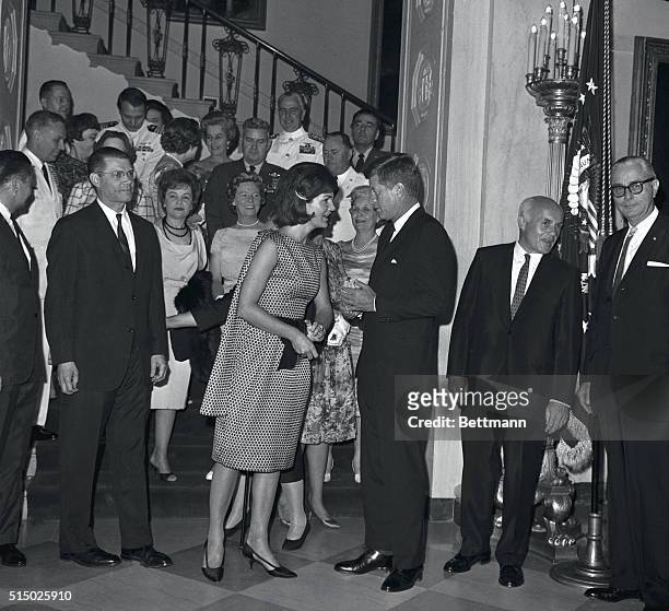 President Kennedy chats with the First Lady as they pose with guests at a reception they gave at the white House for top-ranking members of the...