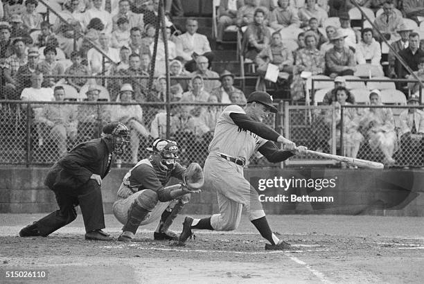 Roger Maris of the New York Yankees watches his first homer of spring training exhibition games go over the right field fence in first inning of game...