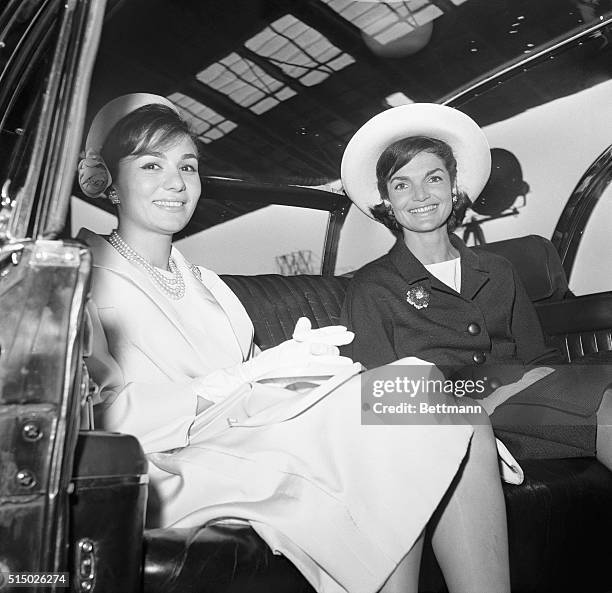 Mrs. Kennedy and Empress Farah ride in a limousine from Washington National Airport today following welcoming ceremonies for Shah Far ah Far ah Far...