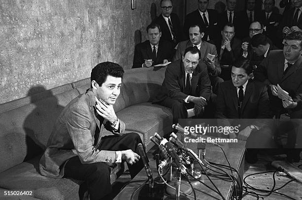 New York: Squashes Rumors. Singer Eddie Fisher sits before a battery of microphones, March 30th, as he denies rumors of a breakup between he and his...