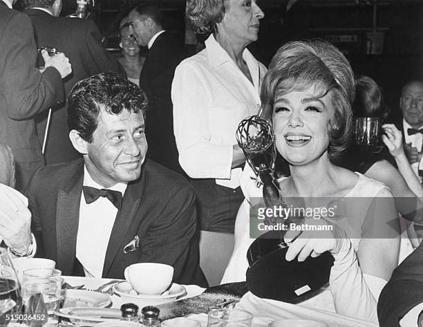 Hollywood: Singer Eddie Fisher glances approvingly at his escort, actress-comedian Edie Adams, as she holds the Emmy awarded her late husband, Ernie...
