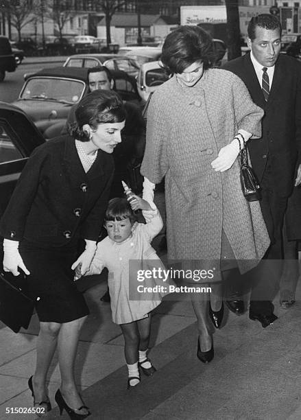 Mrs. Jacqueline Kennedy and her sister, Lee Radziwill, holds the Princess's son, Anthony, 2 1/2, by each hand as they arrive at the Victoria and...
