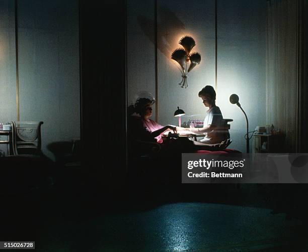 Manhattan, New York, New York: House of Revlon. Woman reads magazine as another has a manicure.