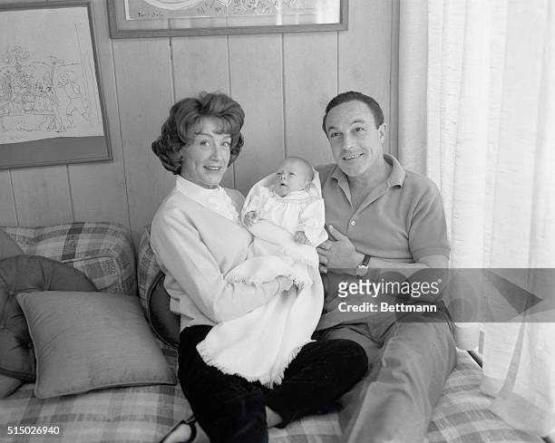 Hollywood: New Baby Boy For Gene Kelly. Gene Kelly and his wife Jeanne smile happily as they display their month old son Timothy before the camera...