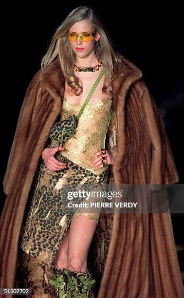 Model presents a leopard print skirt and gold camisole under a fur by John Galliano for Christian Dior during the Autumn-Winter 2000/2001...