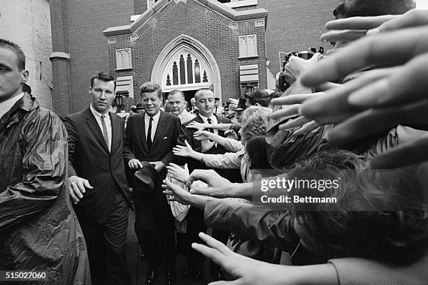 Louisville, KY.: President John F. Kennedy passes by outstretched hands after leaving St. Mary Magdalen's Church here. Kennedy went to airport and on...