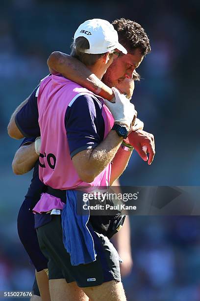 Michael Johnson of the Dockers is assisted from the field after being tackled by Nakia Cockatoo of the Cats during the NAB Challenge match between...