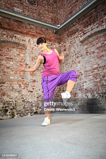 woman wearing sport dress dancing zumba or aerobics in gym - pink shoe stock-fotos und bilder