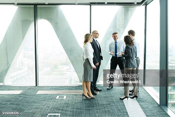 businesspeople in office with woman using digital tablet - business women looking at new office space stockfoto's en -beelden